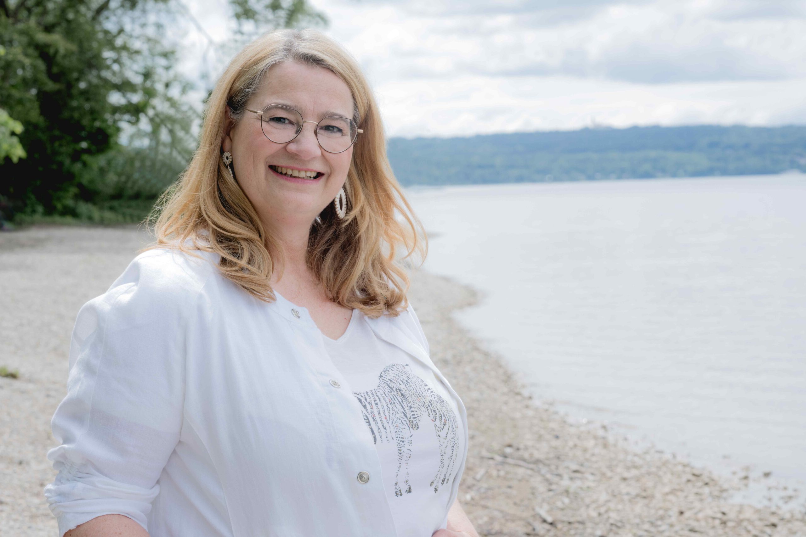 Anja Kruse am See, Wasser im Hintergrund, bereit für deine individuelle Reiseplanung