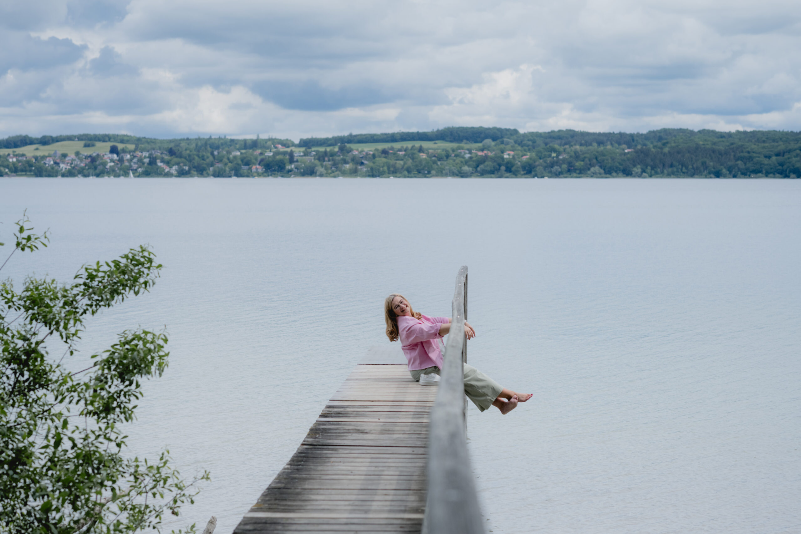 in Reiseserinnerungen schwelgend Anja Kruse am See auf einem Steg