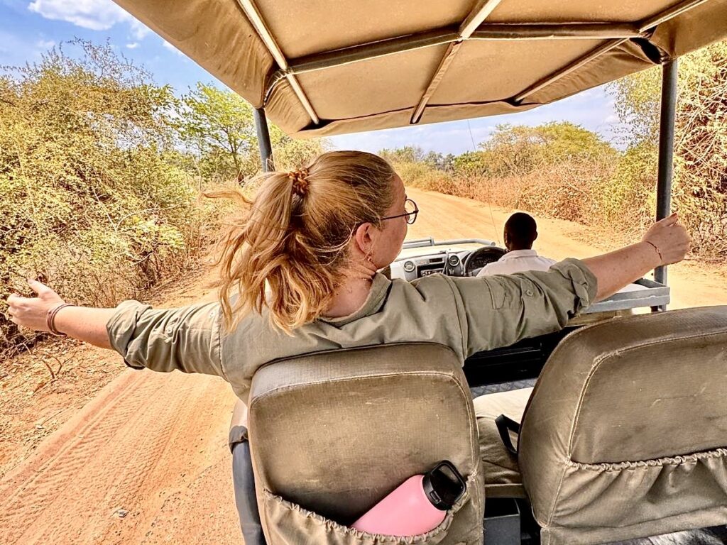 Reisefreiheit Anja Kruse im Jeep unterwegs mit ausgebreiteten Armen